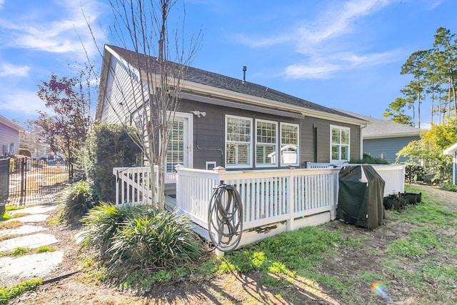 back of property with fence and a deck