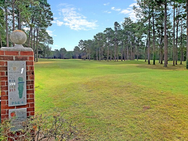 view of property's community with a yard and golf course view