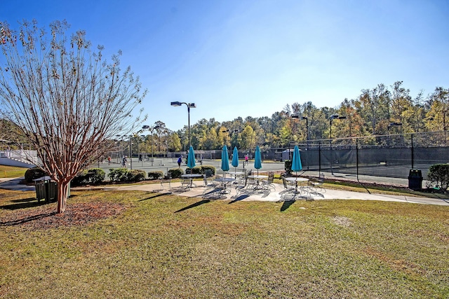 view of community featuring a lawn and fence