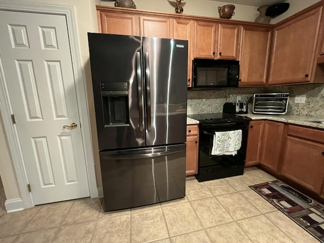 kitchen with black appliances, decorative backsplash, light stone countertops, and light tile patterned floors