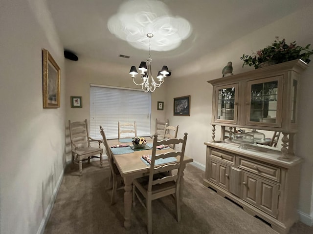 dining space featuring an inviting chandelier and dark colored carpet