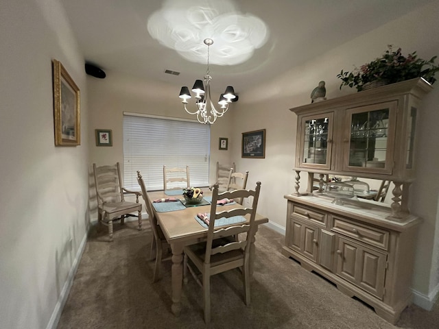 dining room with a chandelier and dark carpet