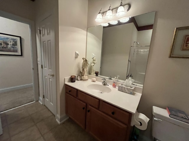 bathroom with tile patterned flooring, vanity, toilet, and walk in shower