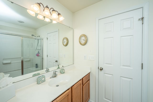 bathroom with a shower with shower door and vanity