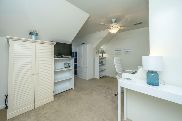 office space with ceiling fan, vaulted ceiling, and light colored carpet