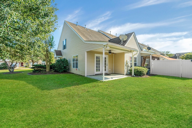 back of property featuring ceiling fan, a patio, and a lawn