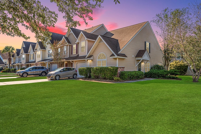 view of front of property with a garage and a lawn