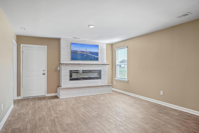 unfurnished living room featuring light hardwood / wood-style floors and a fireplace