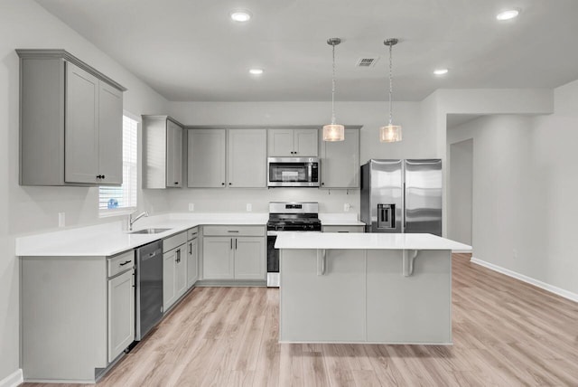 kitchen featuring decorative light fixtures, stainless steel appliances, and gray cabinets