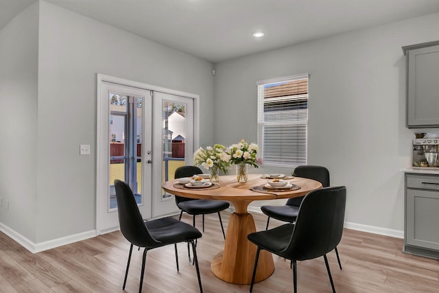 dining space featuring french doors and light wood-type flooring