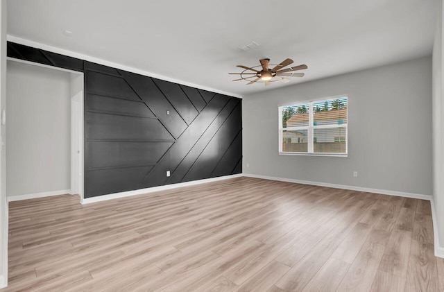 spare room with light wood-type flooring and ceiling fan