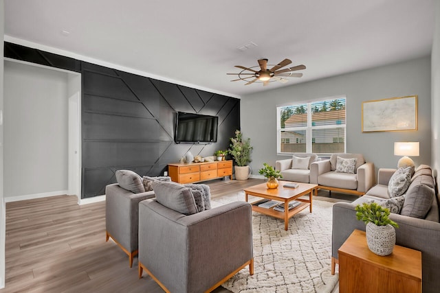 living room featuring light wood-type flooring and ceiling fan