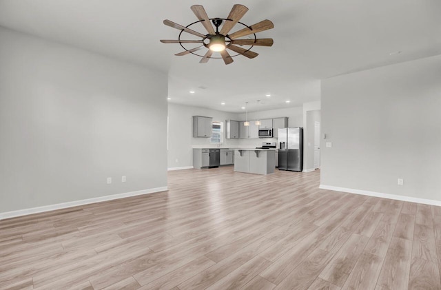 unfurnished living room with ceiling fan and light hardwood / wood-style flooring