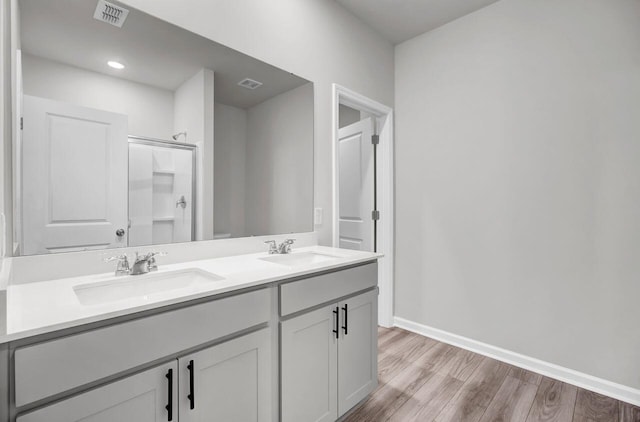 bathroom with hardwood / wood-style floors, vanity, and walk in shower