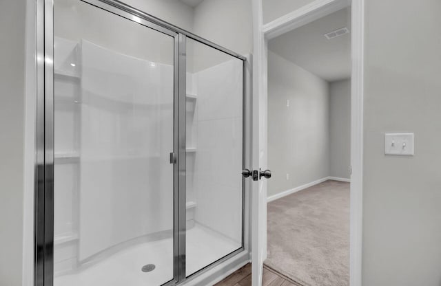 bathroom with wood-type flooring and walk in shower