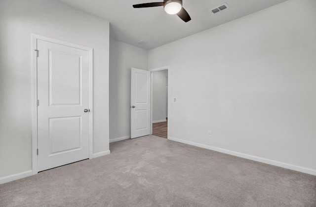 unfurnished bedroom with ceiling fan and light colored carpet