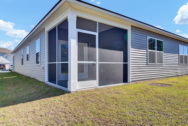 view of home's exterior featuring a sunroom and a yard