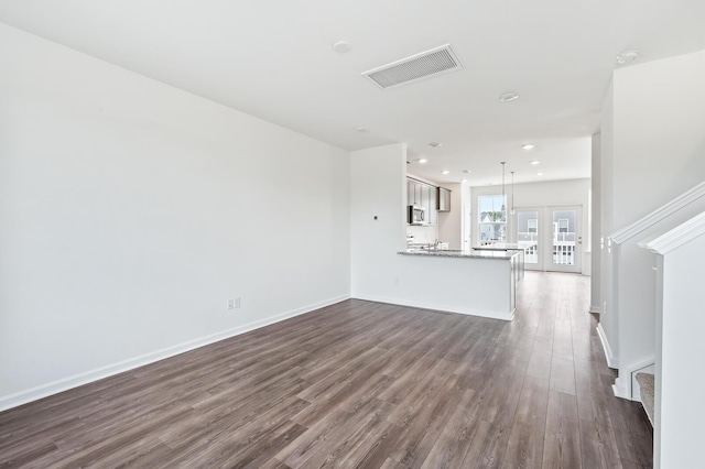 unfurnished living room featuring dark hardwood / wood-style floors and french doors