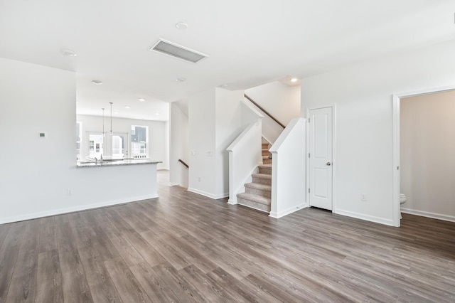 unfurnished living room with hardwood / wood-style flooring and an inviting chandelier