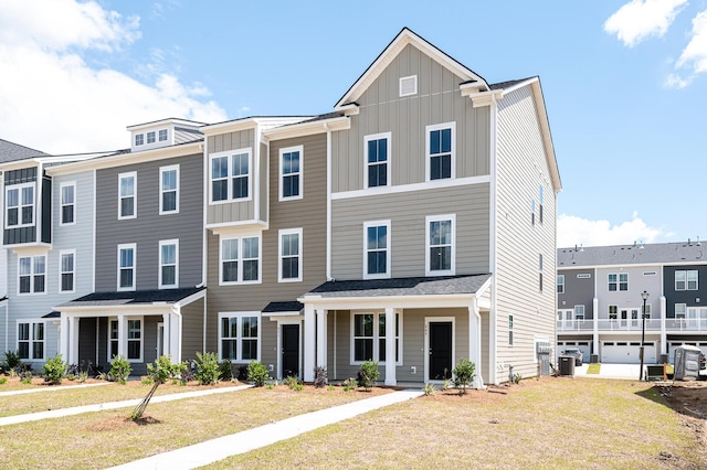 townhome / multi-family property with central AC unit and a front yard