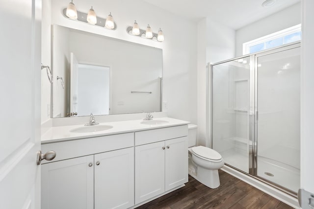 bathroom featuring vanity, hardwood / wood-style flooring, toilet, and walk in shower