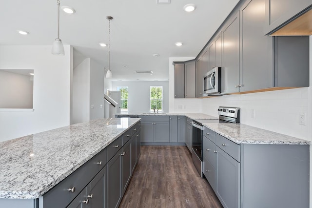 kitchen featuring gray cabinets, dark wood-type flooring, stainless steel appliances, and decorative light fixtures