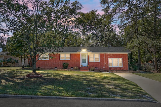 ranch-style home with a yard