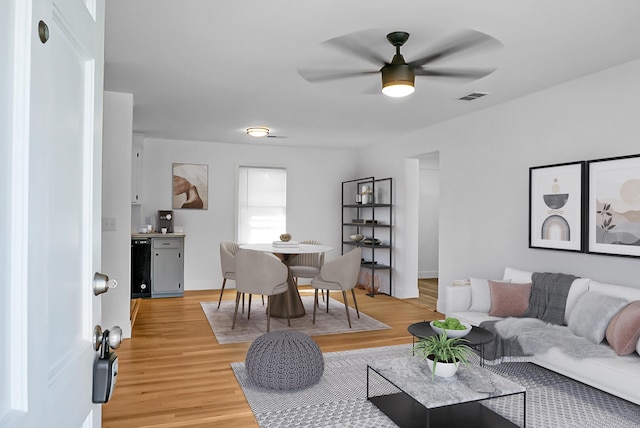 living room featuring light wood-type flooring and ceiling fan