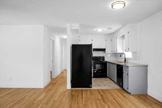 kitchen featuring black appliances, sink, light wood-type flooring, and white cabinets