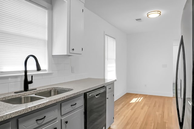 kitchen featuring decorative backsplash, black dishwasher, gray cabinets, light hardwood / wood-style floors, and sink