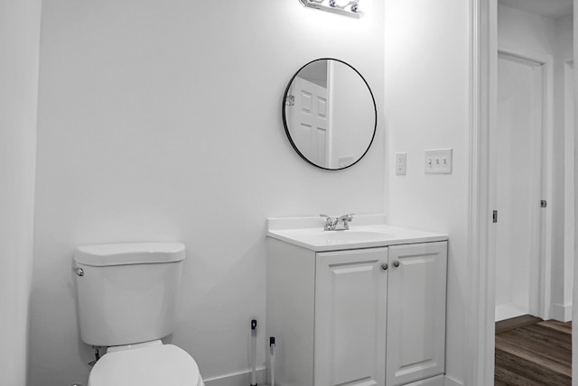 bathroom featuring vanity, toilet, and hardwood / wood-style floors