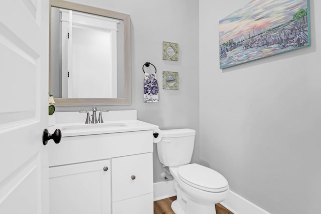 bathroom with vanity, hardwood / wood-style floors, and toilet