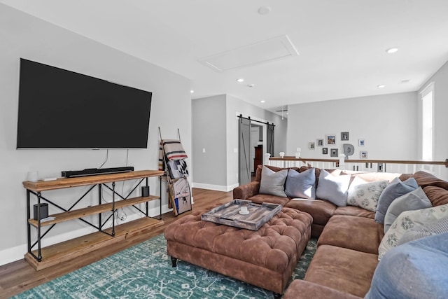 living room with a barn door and hardwood / wood-style floors