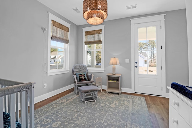 interior space featuring multiple windows, hardwood / wood-style floors, and a notable chandelier