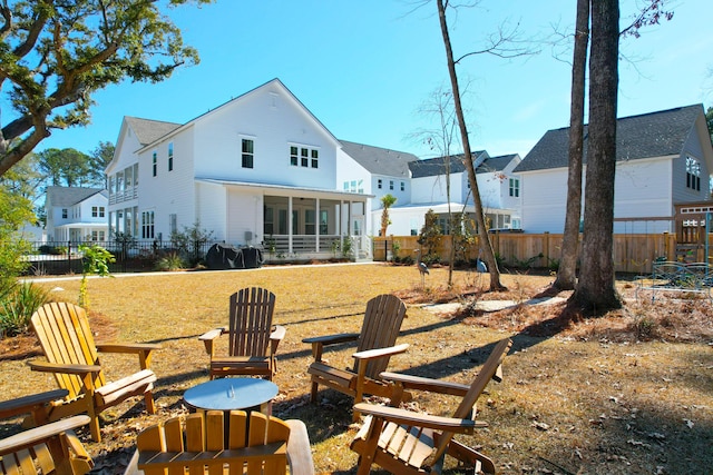 back of house with a sunroom and a fire pit