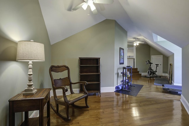 living area with ceiling fan, wood finished floors, and lofted ceiling with skylight