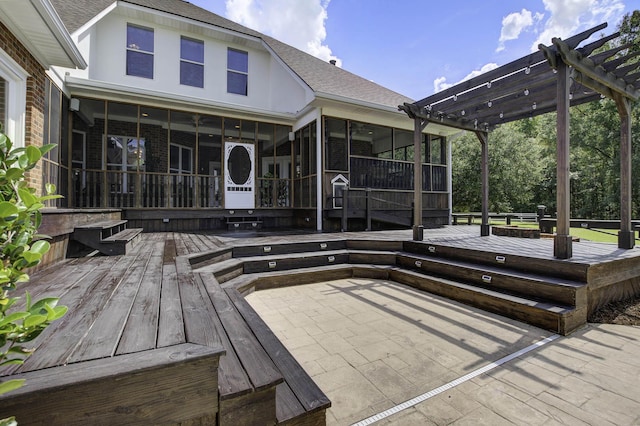 wooden deck with a sunroom, a pergola, and a patio