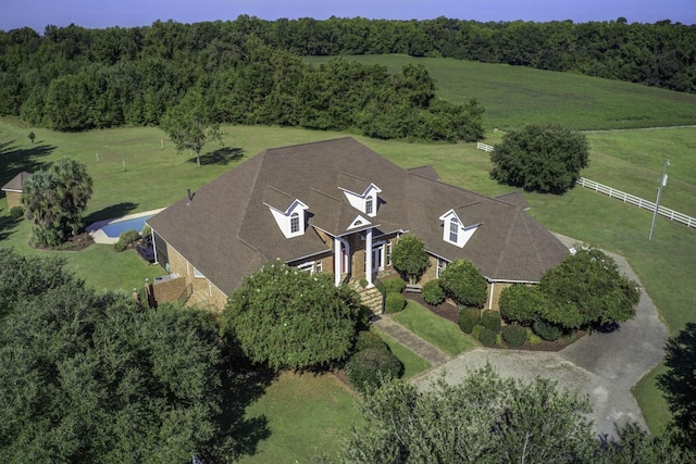 drone / aerial view with a wooded view and a rural view