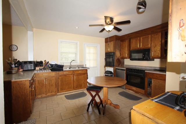 kitchen with brown cabinetry, a sink, black appliances, and a ceiling fan