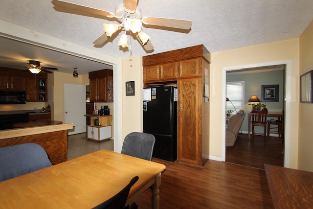 dining space featuring a ceiling fan, dark wood finished floors, a textured ceiling, and baseboards