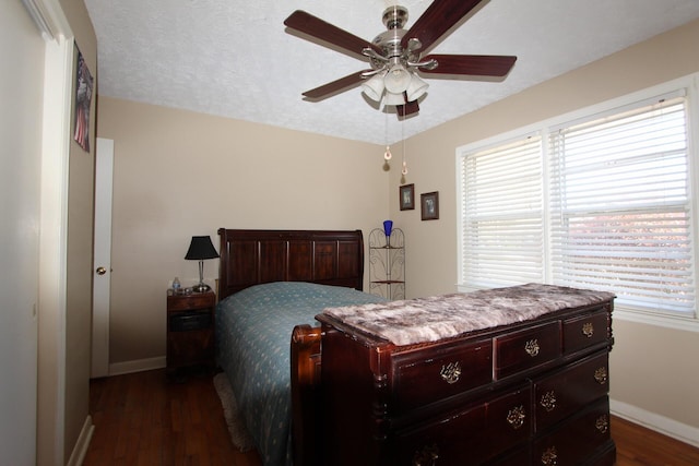 bedroom featuring dark wood-type flooring, ceiling fan, a textured ceiling, and baseboards