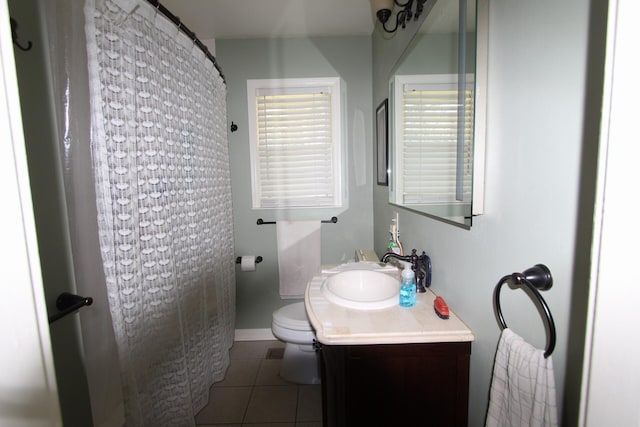 bathroom with a shower with shower curtain, toilet, vanity, baseboards, and tile patterned floors