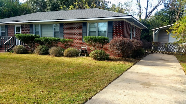 ranch-style house featuring a shingled roof, a front yard, brick siding, and driveway