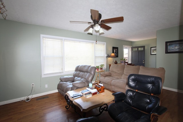 living area featuring a textured ceiling, wood finished floors, visible vents, and baseboards