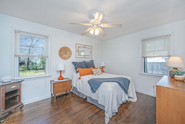 bedroom with ceiling fan, multiple windows, baseboards, and dark wood-style flooring