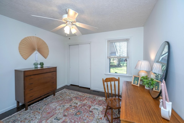 office space featuring a ceiling fan, baseboards, and a textured ceiling