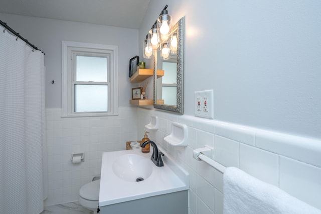 full bathroom featuring wainscoting, toilet, marble finish floor, vanity, and tile walls