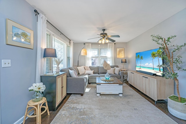 living room with a ceiling fan and dark wood-type flooring