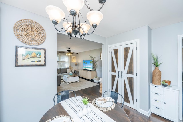 dining area with dark wood finished floors, baseboards, and ceiling fan with notable chandelier