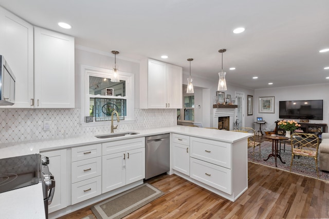 kitchen featuring sink, decorative light fixtures, stainless steel appliances, and kitchen peninsula